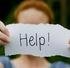 girl holding up a sign asking for help with her hoarder house situation in Sarasota, FL