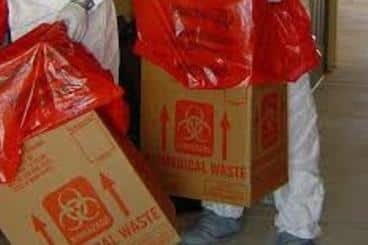 Men in hazmat cleanup suits cleaning up a biohazard